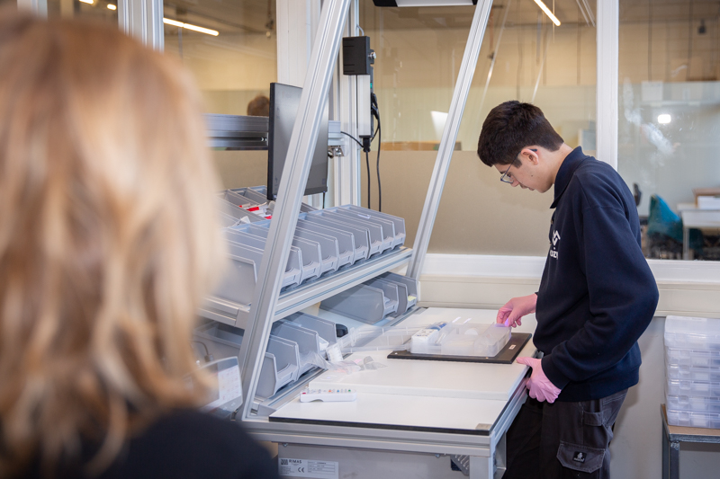 Een collega laat zien hoe de smart beamer werkt door een tandartskoffer in te pakken.